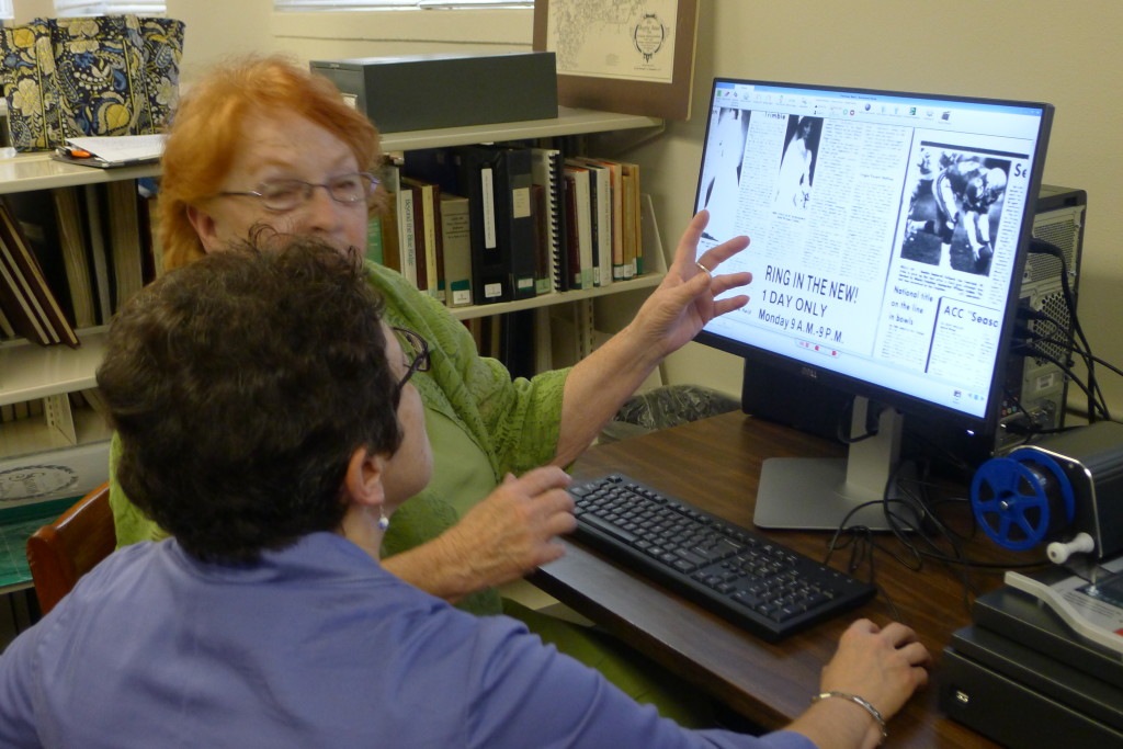 Librarian assisting woman with new microfilm reader