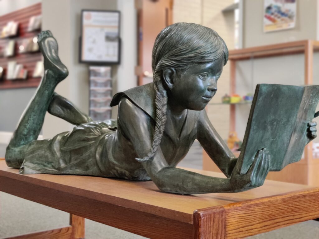 statue of a girl reading a book